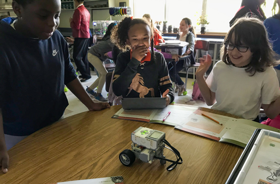 Children at a robotics class, programming a robot