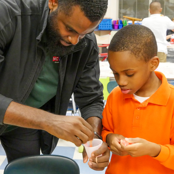 4-H Agent showing an elementary student how to make slime