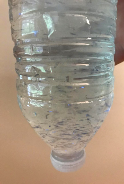 bottle with soap, glitter, and water twirled around to make a water tornado